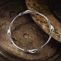 Skilfully wrought in sterling silver, this exotic Mughal-style bangle is decorated with exquisite
