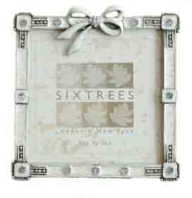 An enamel and pewter frame with a tied bow at the top  makes an ideal frame to hold a picture of