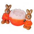 Two happy bunnies clutching a bright orange candle