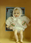 This delightful Heidi Ott baby girl is in 1:12 scale and she is dressed in a cream crochet