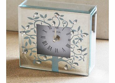 This simple but stunning Hestia Mirror Glass Leaf and Crystal Square Mantel Clock would make a beautiful accessory for any home.This clock is made from mirrored glass in a square block style. The front has a square opening which shows the clock face 