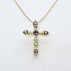 In an exquisitely delicate design, this hallmarked 9ct gold pendant cross is set with peridot and