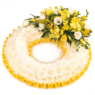 An exquisite massed wreath finished with a elegant spray in gold shades.