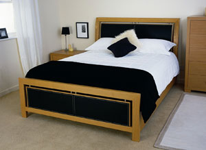 Featuring a blend of solid oak and oak veneers with stitched upholstered leather in the head and