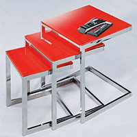 A chrome nest of tables with bright red glass tops