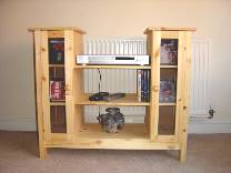 Audio unit in solid natural pine. Features two framed glass doors, with four pull out CD storage