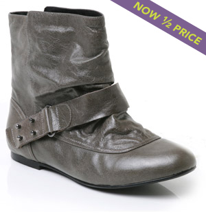 Flat, round toe leather ankle boot featuring strap with buckle detail. Stylish and comfortable, the 